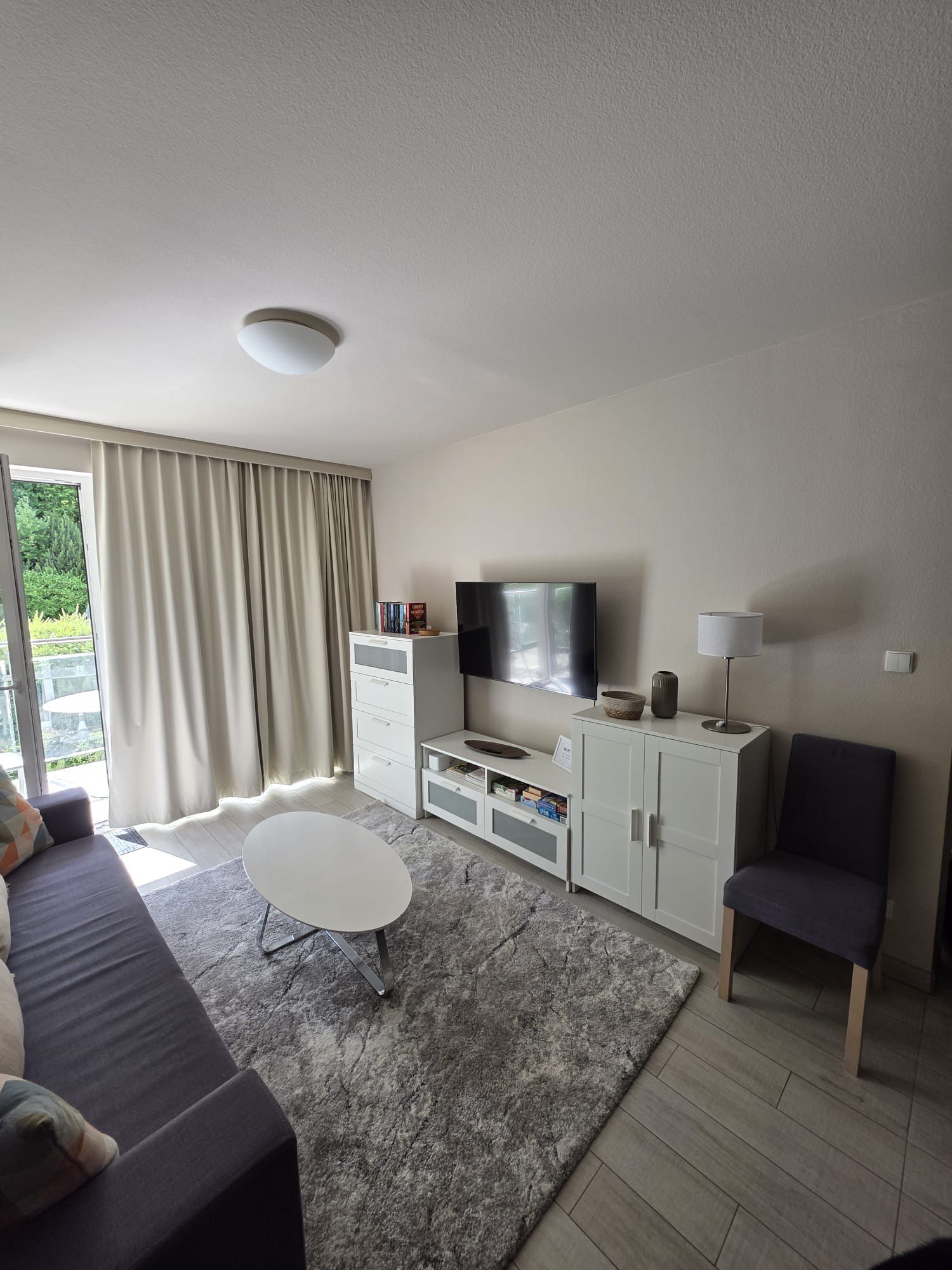 Jasny salon apartamentu Czarna Góra Resort Bormio 25 z sofą, Smart TV i wyjściem na balkon